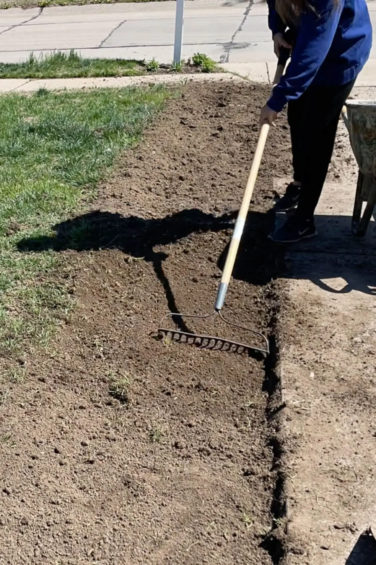 Preparing the ground for a DIY paver driveway extension.